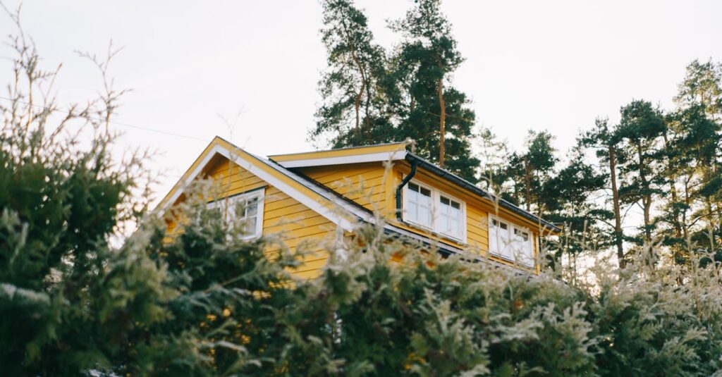 A picturesque yellow house surrounded by lush green trees, ideal for country living.