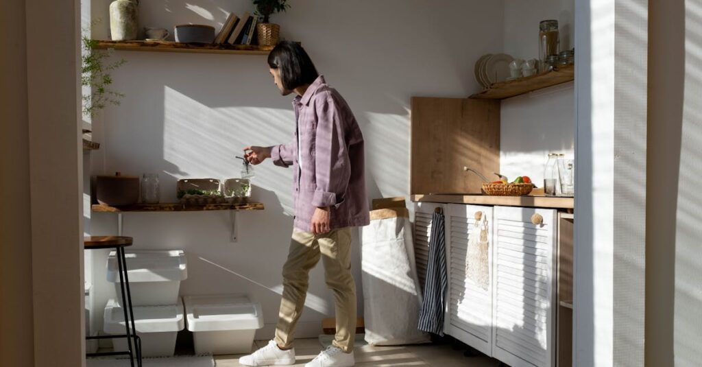 Man in casual wear tending to indoor plants in a sunlit kitchen.