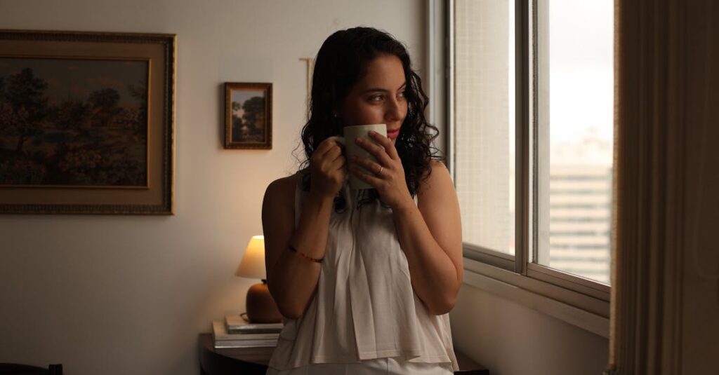 Young woman gazing out window with coffee, enjoying morning indoors.