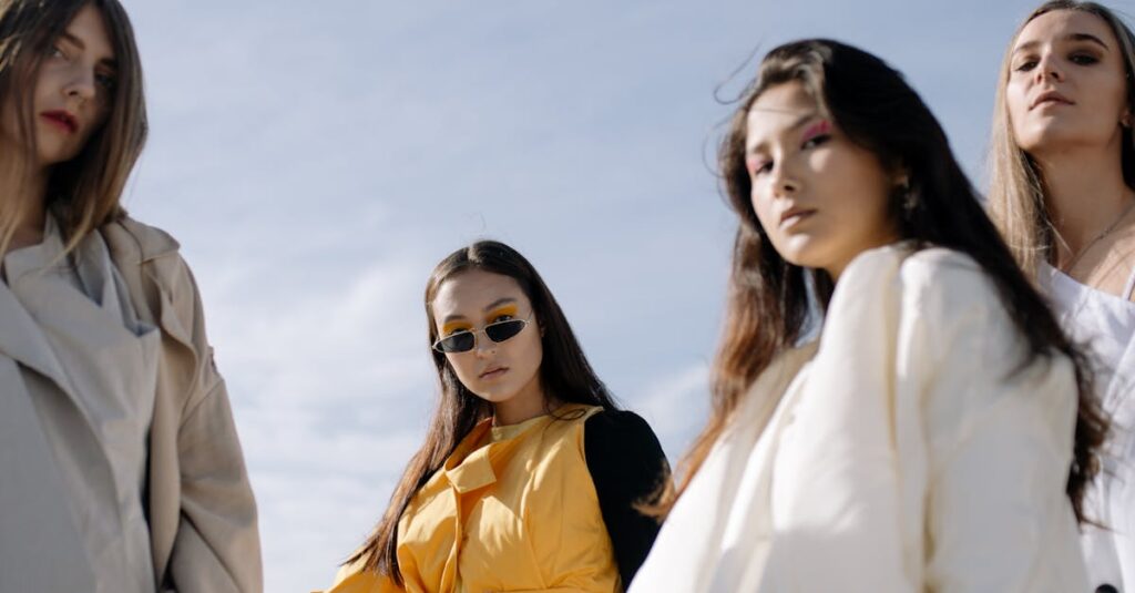 Fashionable women posing confidently in chic outfits under the clear sky.