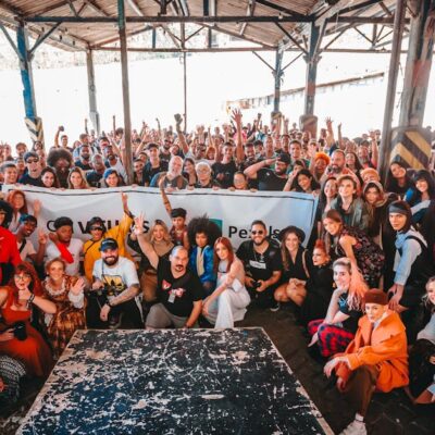 Vibrant group photo in a warehouse in Rio de Janeiro showcasing diversity and togetherness.