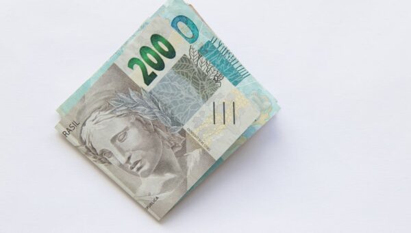 Stack of 200 Brazilian Real banknotes isolated on a white surface, symbolizing wealth and finance.