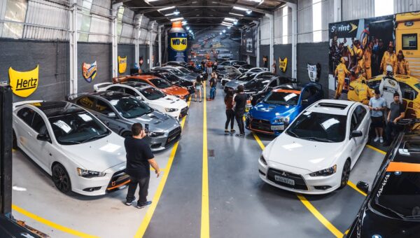 A vibrant scene of a car enthusiast gathering at Vila Nair, showcasing a variety of vehicles indoors.