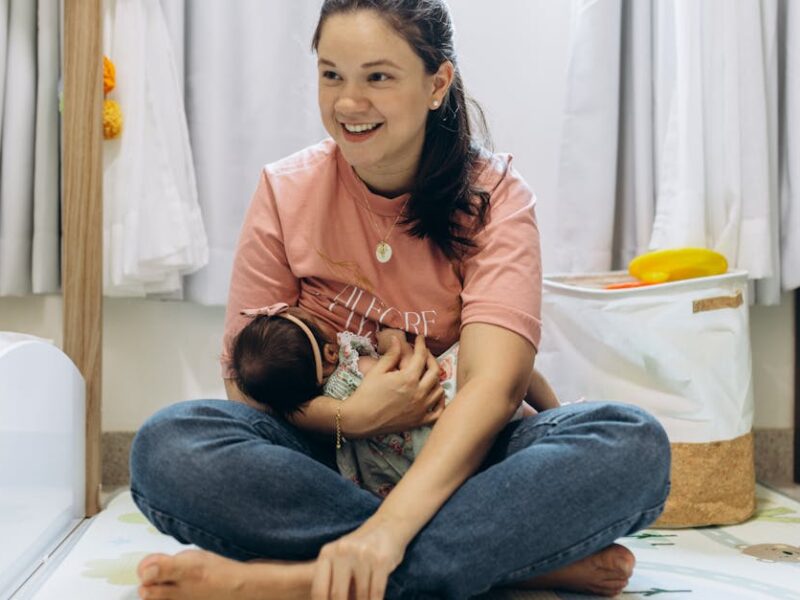 A joyful mother holding her baby in a bright, cozy room, showcasing motherhood and family warmth.