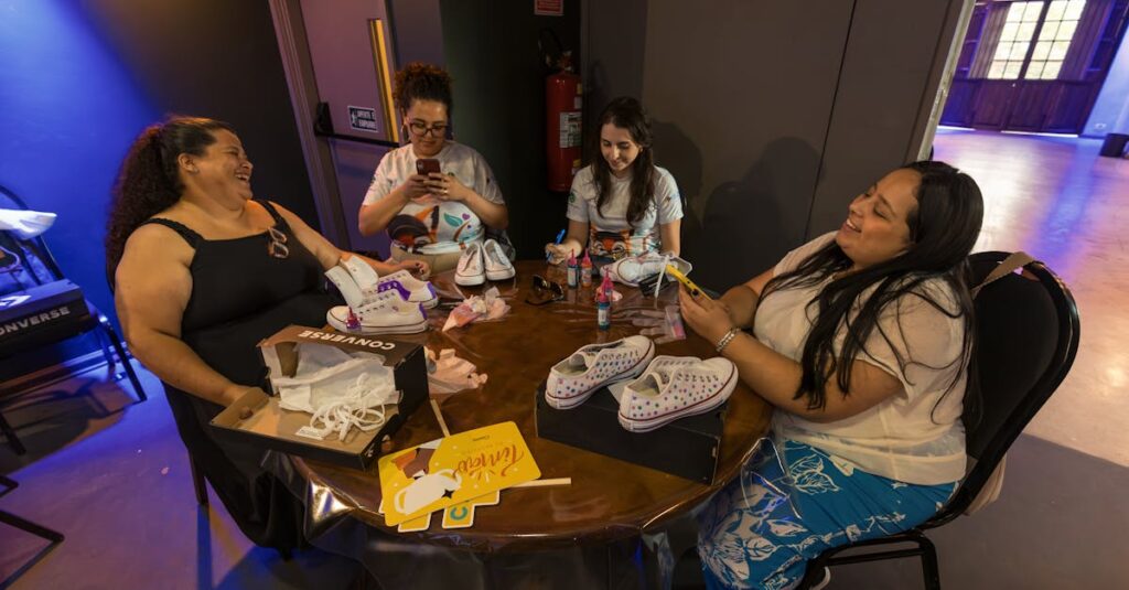 A group of women creatively painting sneakers at an indoor art workshop, showcasing teamwork and creativity.