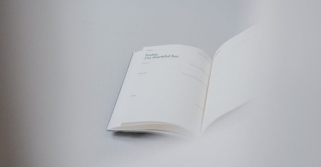 From above of opened notebook with empty pages placed on white working table