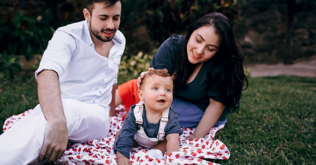 A joyful family enjoying a picnic outdoors during summer. Smiling parents with their baby on a blanket.
