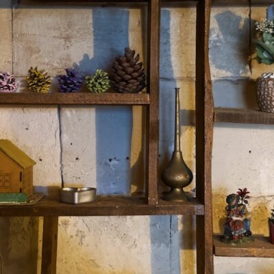 Rustic wooden shelf adorned with ornaments, plants, and decorative objects, creating a cozy indoor ambiance.