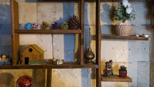 Rustic wooden shelf adorned with ornaments, plants, and decorative objects, creating a cozy indoor ambiance.