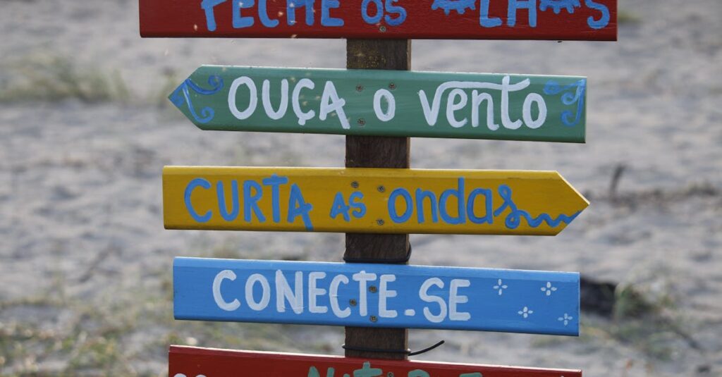 Vibrant wooden sign with motivational phrases on a beach in Guaratuba, Brazil.