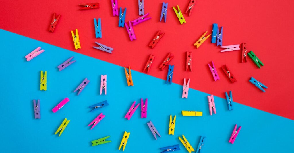 Colorful clothespins scattered on a contrasting red and blue background for a vibrant look.