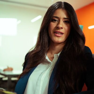 Professional woman in a modern office environment engaging in a business meeting.