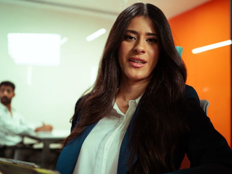 Professional woman in a modern office environment engaging in a business meeting.