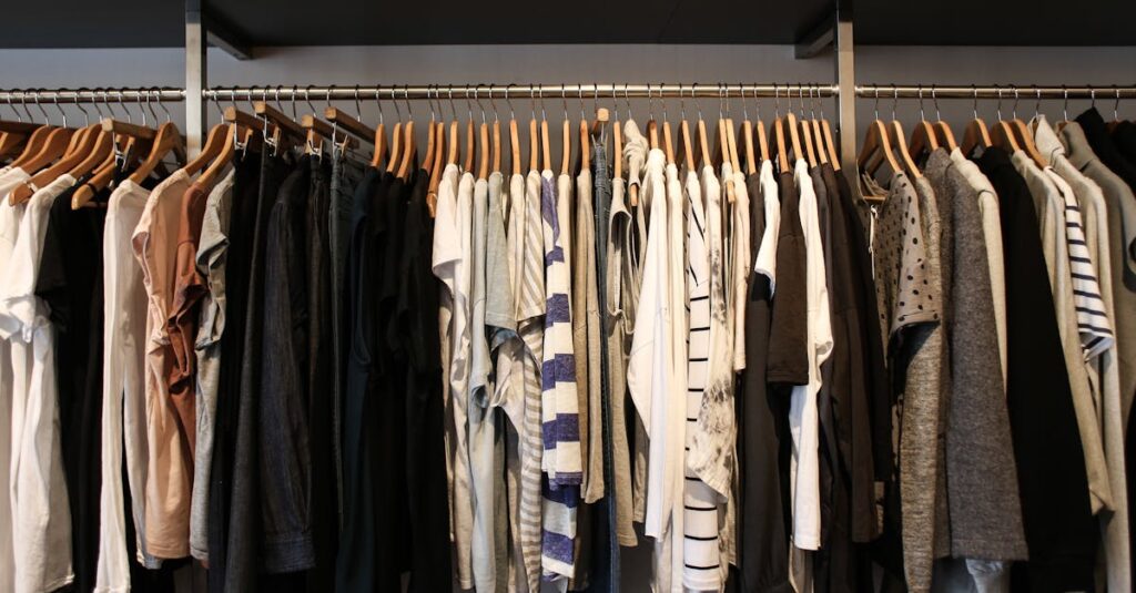 Diverse range of fashionable clothes on wooden hangers in a boutique setting.