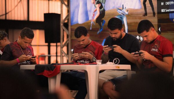 Group of gamers intensely focused during a mobile e-sports tournament indoors.
