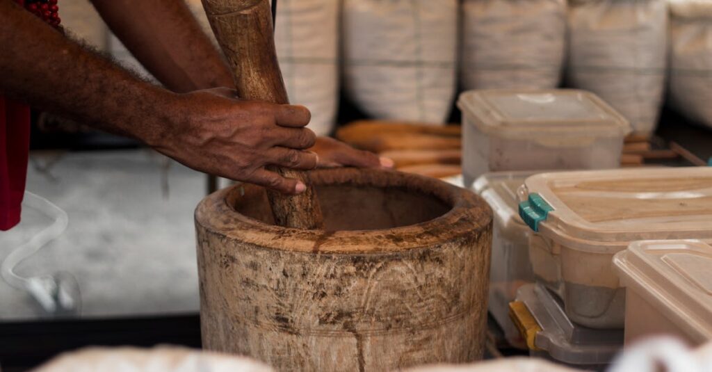Close-up of hands grinding herbs in a wooden mortar at a São Paulo market stall.