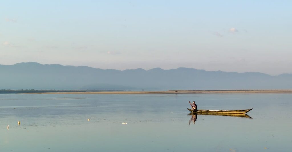 A serene view of a fisherman in a boat on the calm Brahmaputra River near Biswanath Charali, Assam.