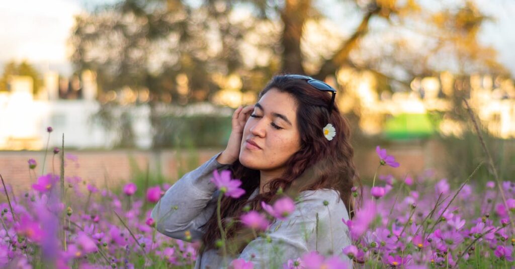 Young woman enjoying a moment in a field of vibrant purple cosmos flowers.