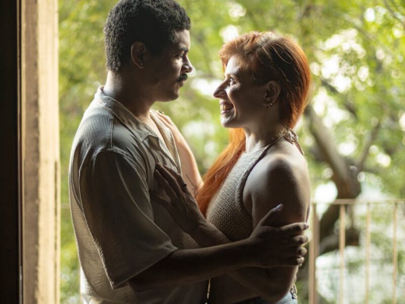 A loving couple sharing a tender moment by a doorway with natural light flowing in. Captured in Buenos Aires.