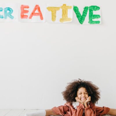 Smiling child engaging in creative art with playful expression indoors.