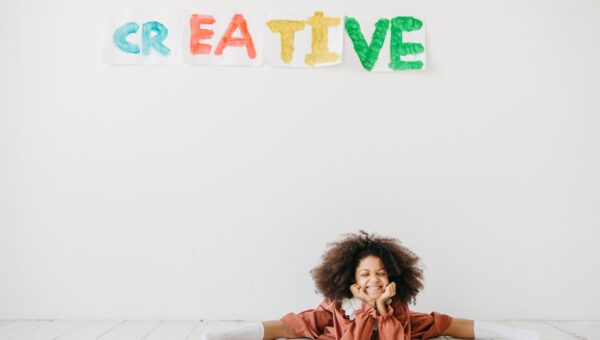 Smiling child engaging in creative art with playful expression indoors.