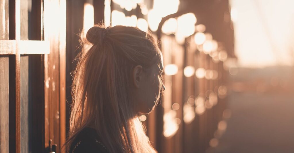 Silhouette of a woman with long hair against a sunset backdrop in Póvoa de Santa Iria, Portugal.