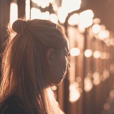 Silhouette of a woman with long hair against a sunset backdrop in Póvoa de Santa Iria, Portugal.