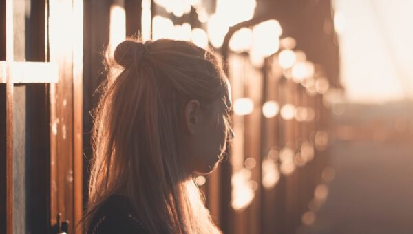 Silhouette of a woman with long hair against a sunset backdrop in Póvoa de Santa Iria, Portugal.