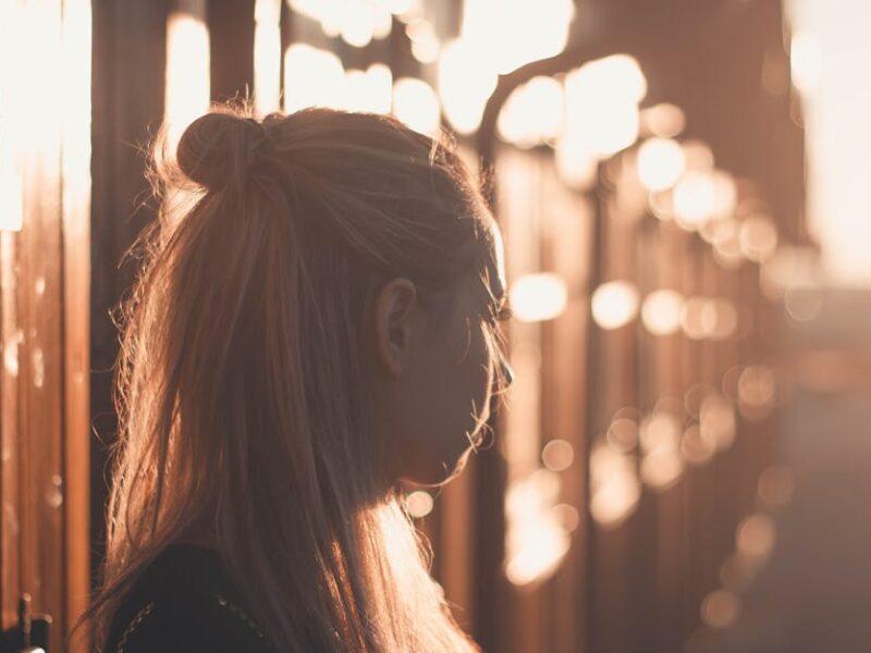 Silhouette of a woman with long hair against a sunset backdrop in Póvoa de Santa Iria, Portugal.