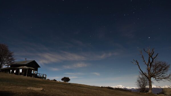 Peaceful starry night scene over a wooden cabin in El Bolsón, Argentina.