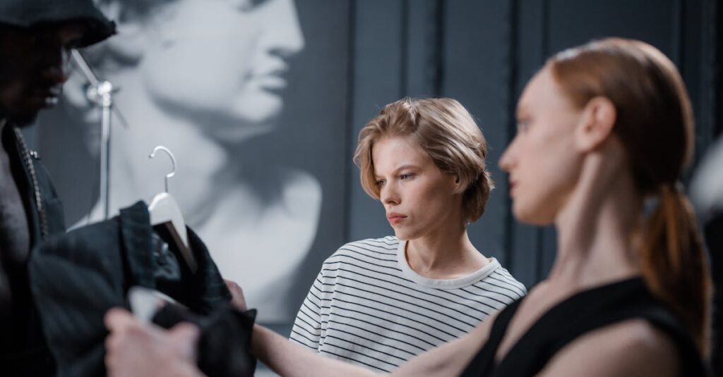 Fashion designers collaborate while reviewing a garment in a modern studio setting.