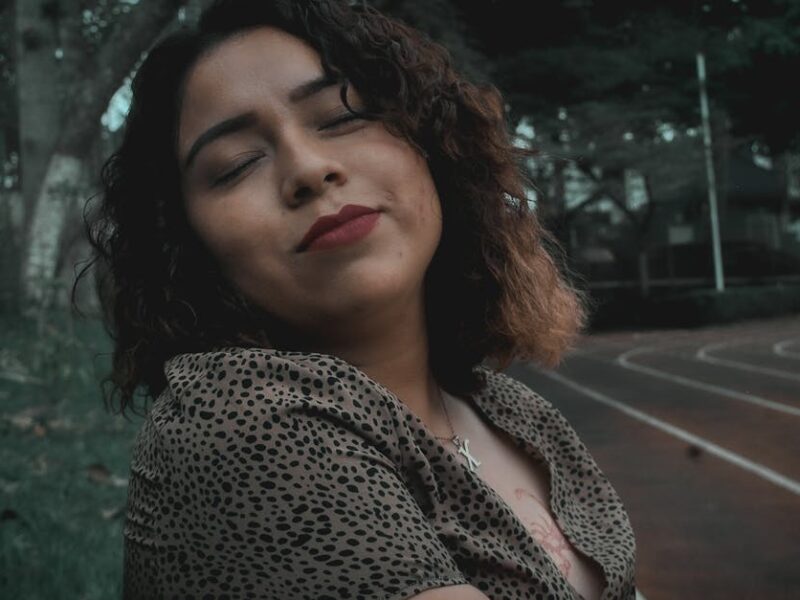 Portrait of a serene woman with curly hair, enjoying autumn in a Huatusco park.