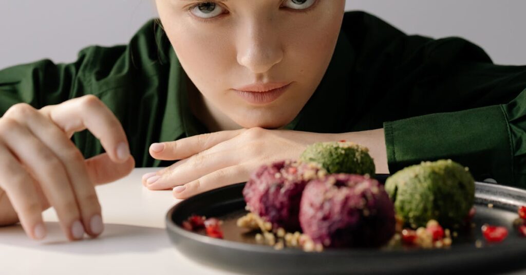 A woman intently observing traditional Georgian pkhali on a plate, showcasing beetroot and spinach varieties.