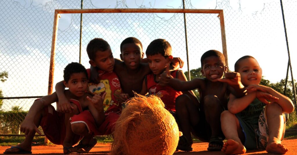Como a Despersonalização Pode Impactar seu Bem-Estar Emocional 2 Group of kids enjoying a lively game of soccer in a Rio de Janeiro neighborhood.