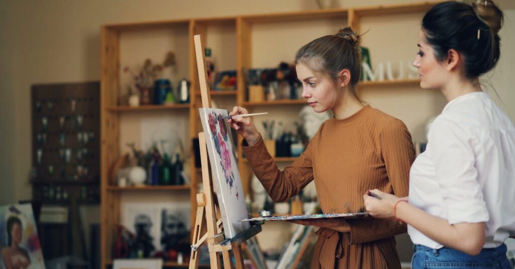 Two women engaged in creating art on canvas, showcasing creativity and concentration.