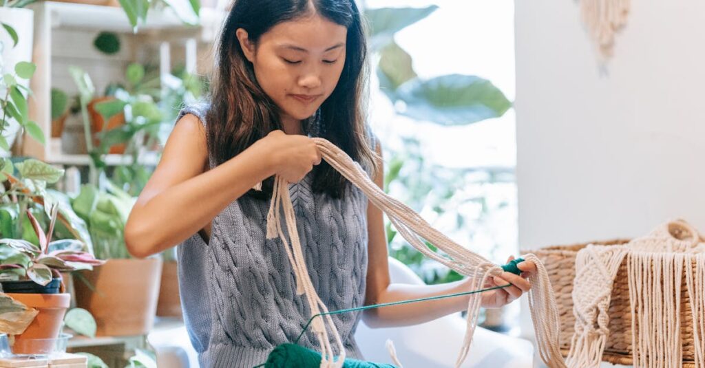 Asian woman skillfully crocheting with yarn in a comfortable indoor space surrounded by plants.