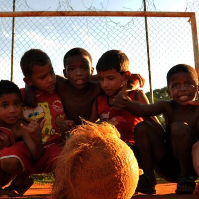 Group of kids enjoying a lively game of soccer in a Rio de Janeiro neighborhood.