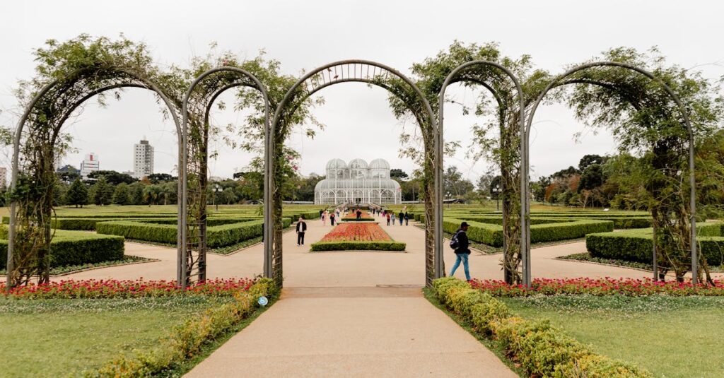 A scenic view of Curitiba's iconic botanical garden with lush greenery and elegant archway.