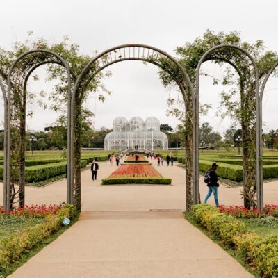 A scenic view of Curitiba's iconic botanical garden with lush greenery and elegant archway.