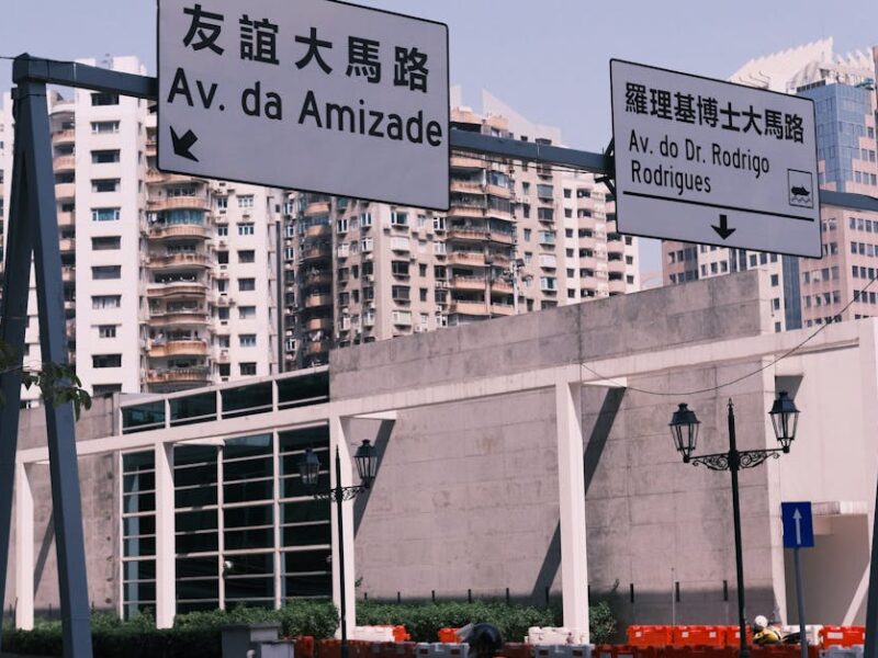 Street view in Macau with bilingual road signs and urban architecture.