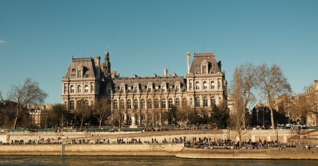 Como Transformar sua Vida com Práticas de Autocuidado Diárias 2 Elegant view of a classic Parisian building along the Seine River on a clear day.