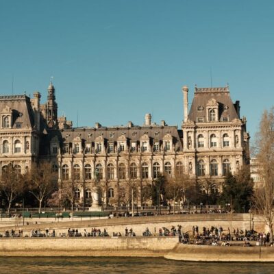 Elegant view of a classic Parisian building along the Seine River on a clear day.
