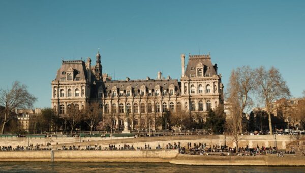Elegant view of a classic Parisian building along the Seine River on a clear day.