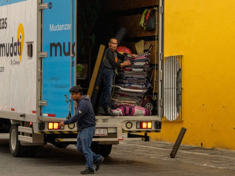 Workers loading a moving truck on a street in Mexico, urban lifestyle.
