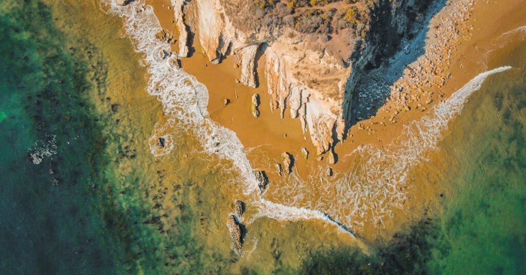 A stunning aerial view of the rugged coastline at Goleta, California with turquoise waters and rocky cliffs.