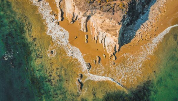 A stunning aerial view of the rugged coastline at Goleta, California with turquoise waters and rocky cliffs.