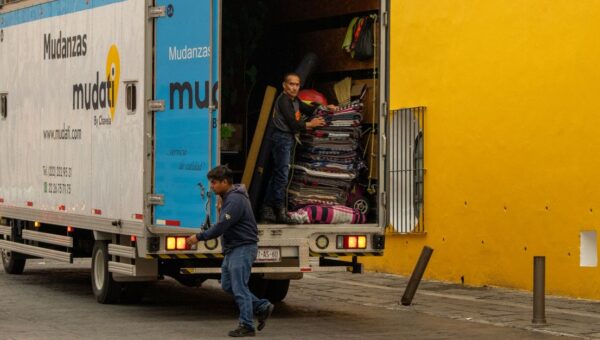 Workers loading a moving truck on a street in Mexico, urban lifestyle.