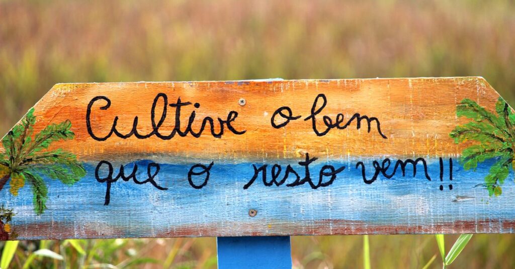 Crafted wooden sign with positive message in a Guaratuba field, Paraná, Brazil.