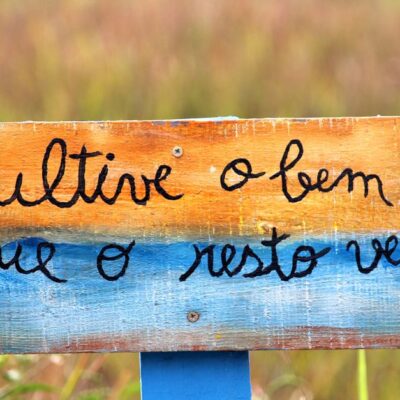 Crafted wooden sign with positive message in a Guaratuba field, Paraná, Brazil.