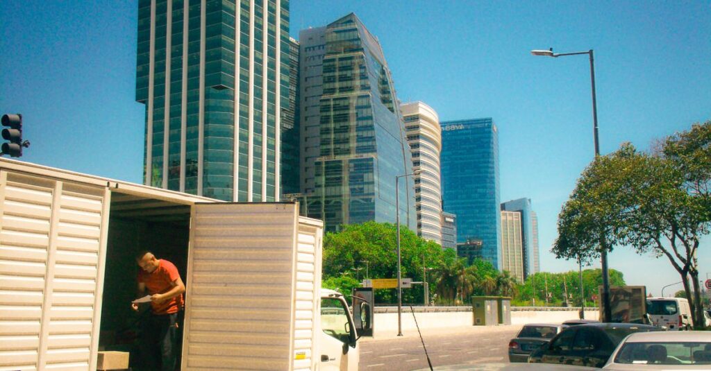 Urban scene in Buenos Aires with skyscrapers and delivery activity on a sunny day.